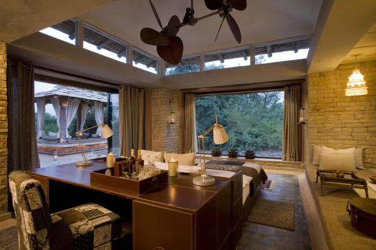 Luxury safari lodge with an open-air design, earthy interiors, and a scenic jungle view.