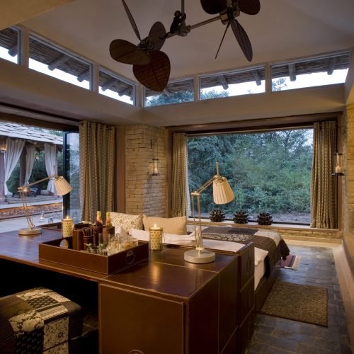 Luxury safari lodge with an open-air design, earthy interiors, and a scenic jungle view.